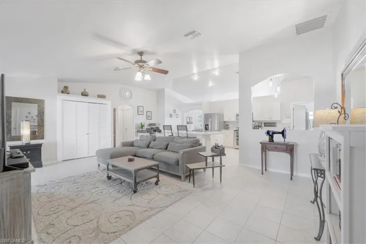Tiled living room featuring lofted ceiling and ceiling fan