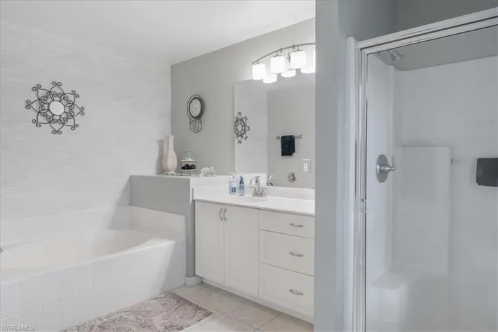 Bathroom featuring tile patterned floors, plus walk in shower, and vanity