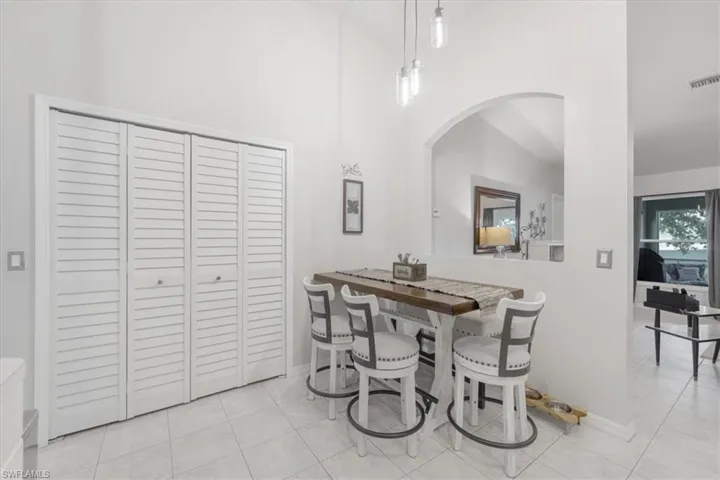 Tiled dining space featuring high vaulted ceiling