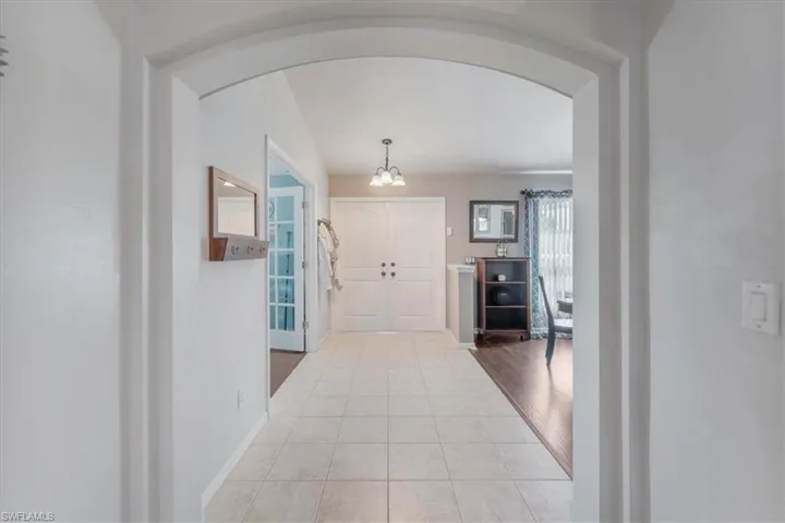 Corridor with a notable chandelier and hardwood / wood-style floors