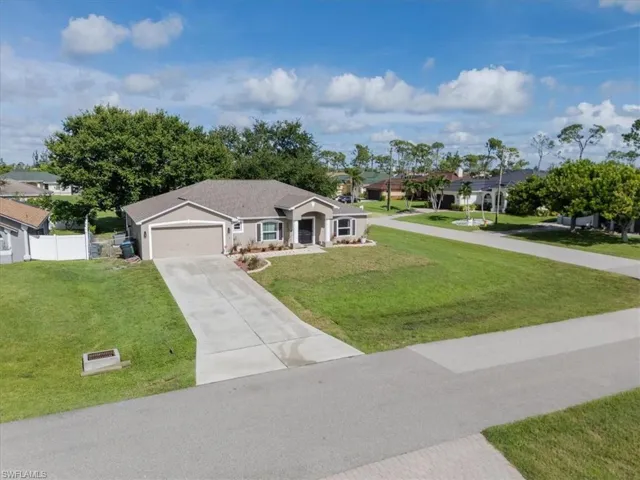 Ranch-style house featuring a garage and a front yard