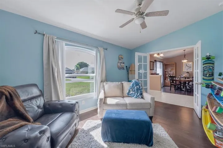 Tiled living room featuring vaulted ceiling and ceiling fan