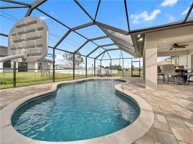 View of pool featuring ceiling fan, a lanai, a yard, and a patio
