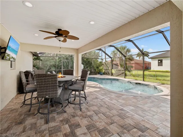 View of pool with a patio area, a lanai, and ceiling fan