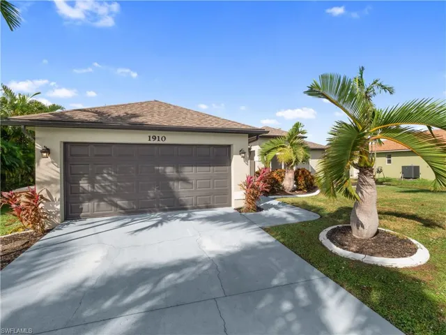 Ranch-style house featuring a front lawn and a garage