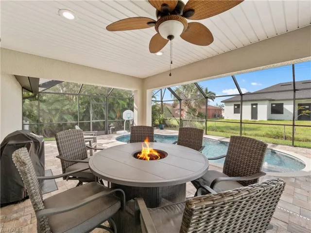 View of patio / terrace with glass enclosure, ceiling fan, and pool water feature