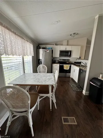 Dining space featuring dark hardwood / wood-style floors, sink, vaulted ceiling