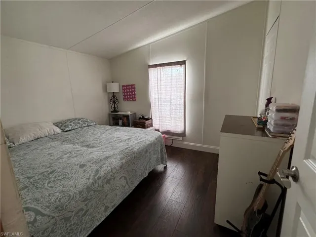 Bedroom featuring vaulted ceiling and dark hardwood / wood-style flooring