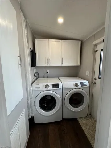 Laundry room featuring washing machine and dryer, hookup for a washing machine, cabinets, and dark wood-type flooring