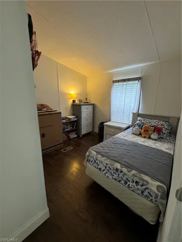 Bedroom with dark wood-type flooring and a textured ceiling