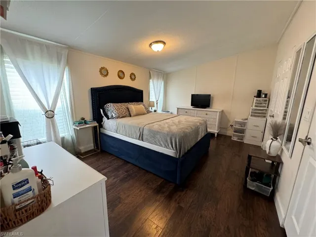 Bedroom featuring dark hardwood / wood-style floors and multiple windows