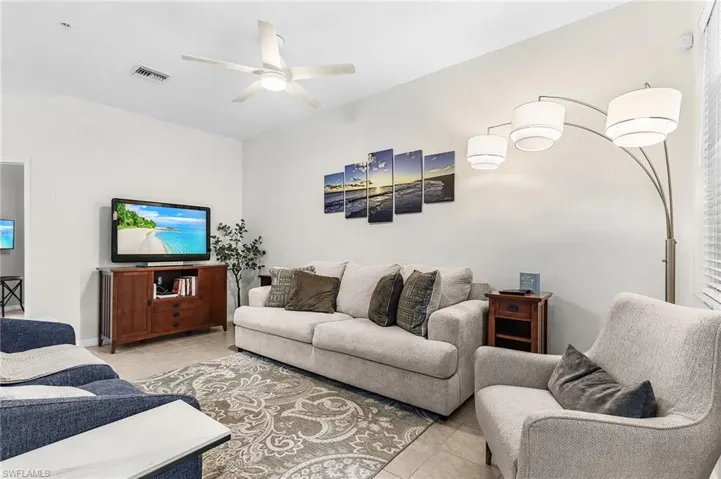 Living room featuring light tile patterned floors and a ceiling fan