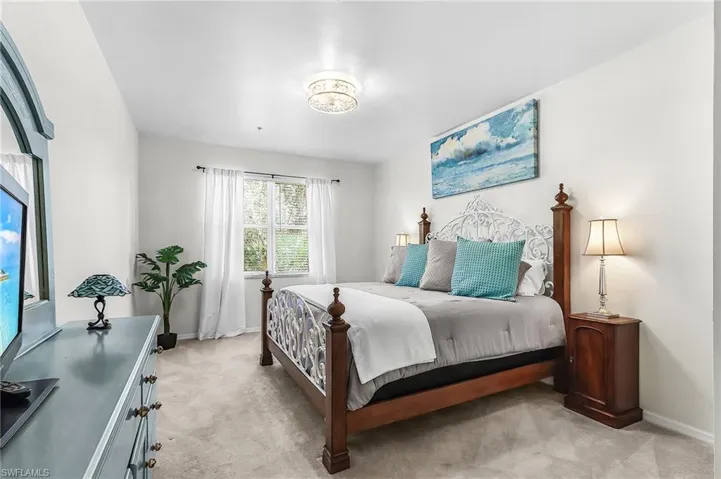 Bedroom featuring light carpet