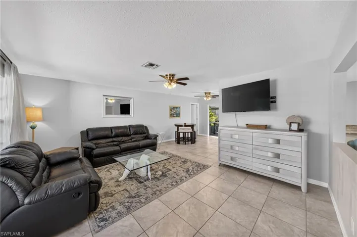 Light gray wall paint, tile flooring, and ceiling fans