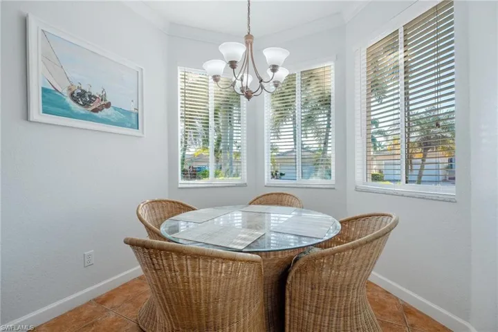Dining area with a healthy amount of sunlight, tile flooring, and crown molding