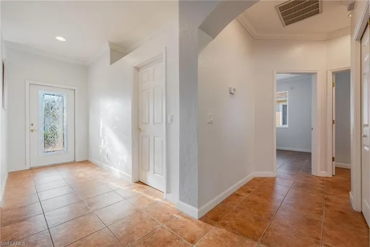 Tiled entryway with plenty of natural light and ornamental molding