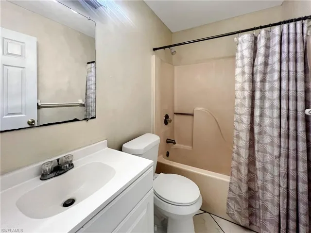 Full bathroom featuring shower / bath combo, vanity, and toilet