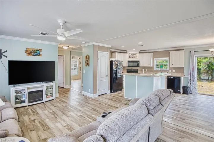 Living area featuring ornamental molding, ceiling fan, light wood-type flooring, and recessed lighting