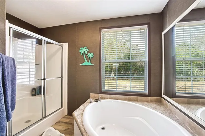 Bathroom featuring a bath, a stall shower, and light wood-type flooring