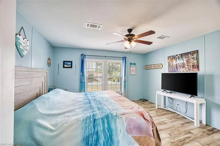 Bedroom featuring a textured ceiling, wood finished floors, and a ceiling fan
