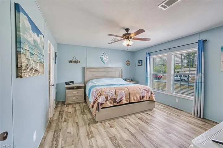 Bedroom featuring light wood-style flooring, ceiling fan, and a textured ceiling