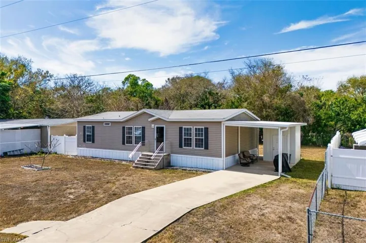 Manufactured / mobile home featuring driveway and a carport