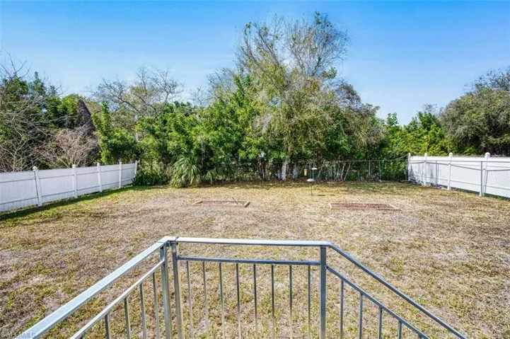 Fenced backyard featuring a balcony