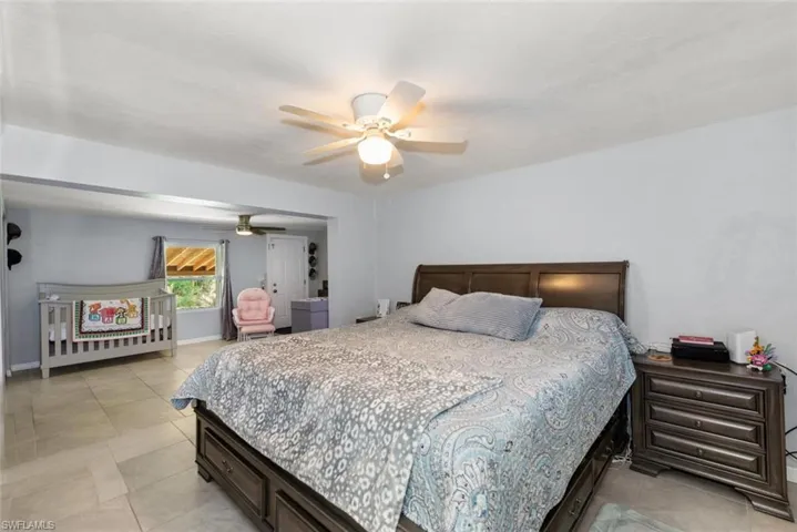 Bedroom featuring light tile patterned flooring, baseboards, and ceiling fan