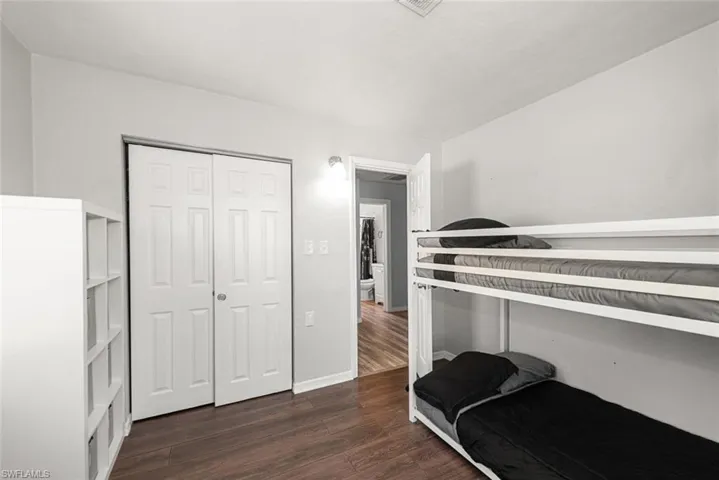 Bedroom featuring baseboards, a closet, and wood finished floors