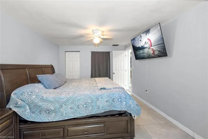 Bedroom featuring baseboards, a closet, ceiling fan, and light tile patterned floors