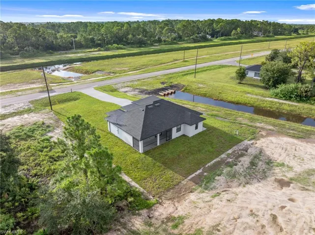 Birds eye view of property with a water view