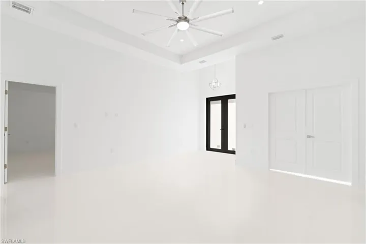 Unfurnished room with a high ceiling and ceiling fan