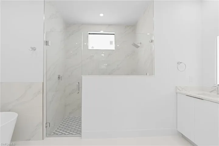 Bathroom featuring vanity, walk in shower, and tile patterned floors