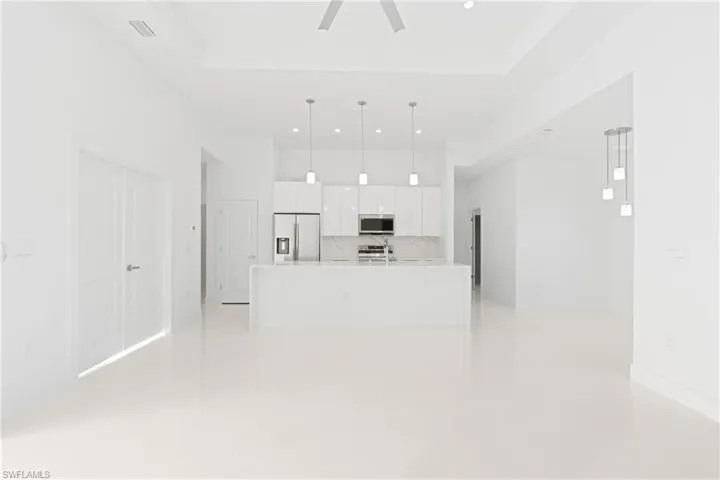 Unfurnished living room with light tile patterned floors and a tray ceiling