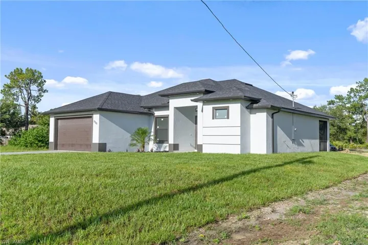 View of front of house with a garage and a front yard