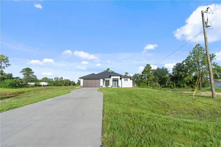 Ranch-style home with a garage and a front lawn