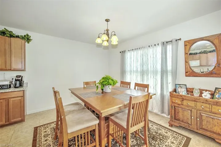 Dining space featuring light tile patterned floors and a chandelier