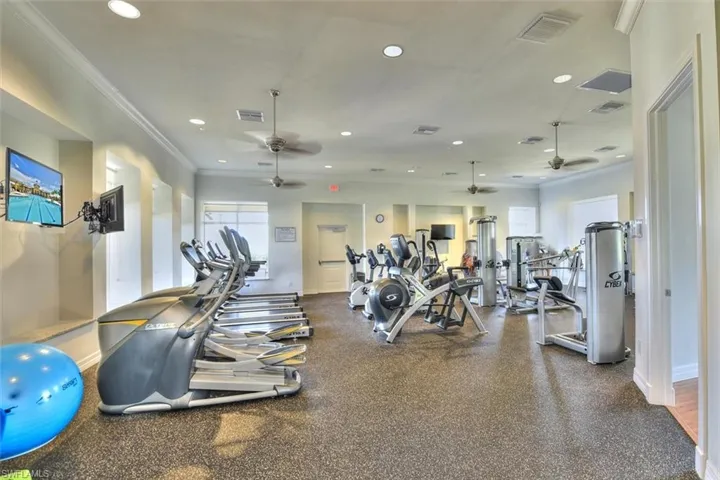 Gym with ornamental molding and ceiling fan