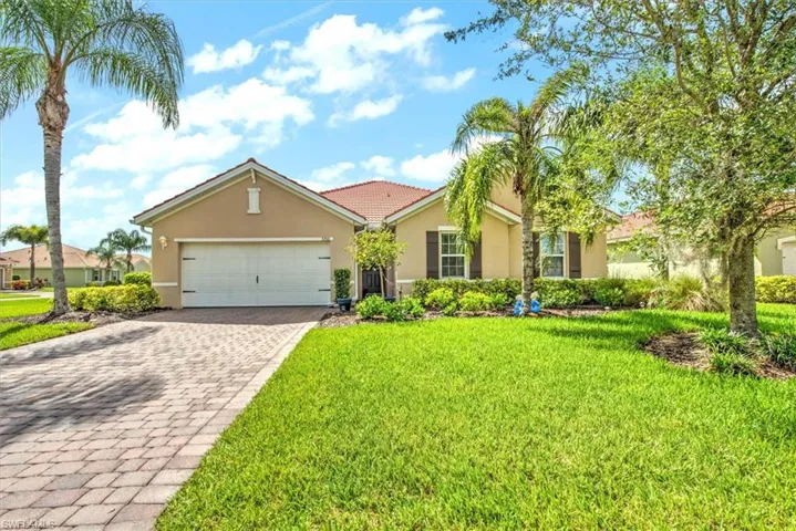 View of front of property with a garage and a front lawn