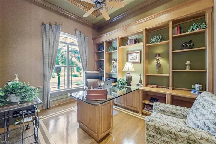 Den with custom built-ins and beauty of glass desk.