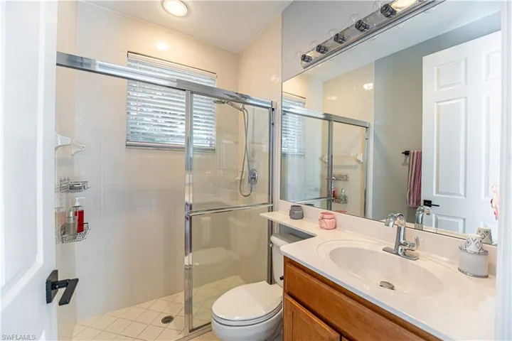 Bathroom featuring a shower with shower door, toilet, and vanity