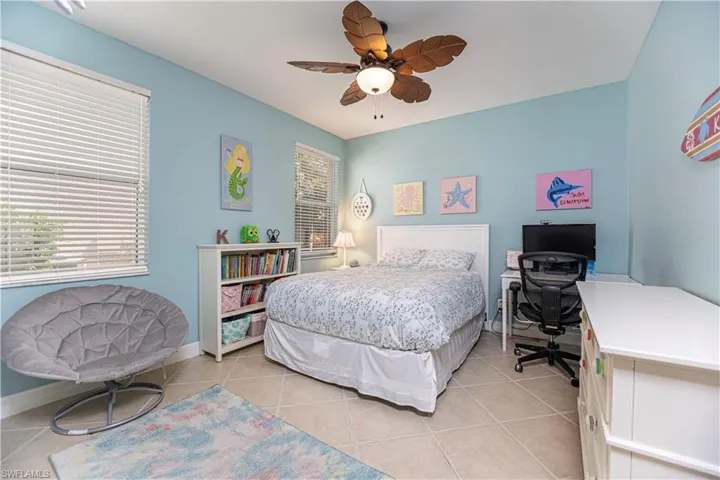 Tiled bedroom featuring ceiling fan