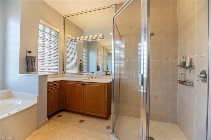 Bathroom with vanity, shower with separate bathtub, and tile patterned flooring