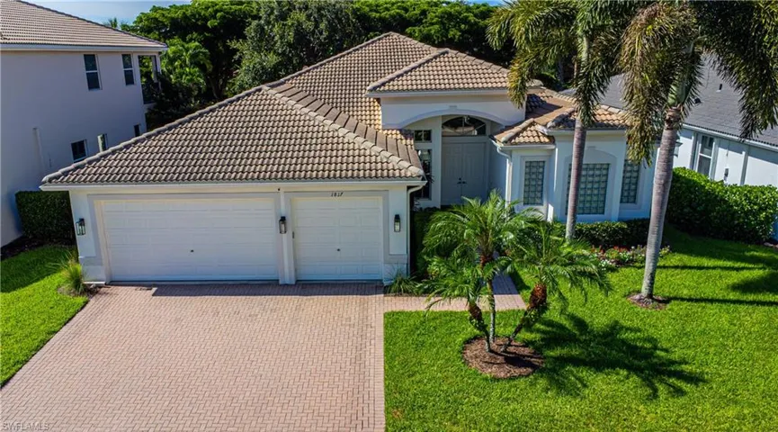 Mediterranean / spanish-style house with a garage and a front lawn