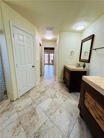 Bathroom with a textured ceiling, an enclosed shower, vanity, and tile patterned floors