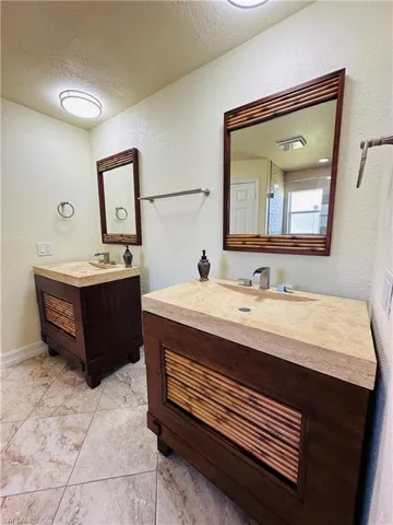 Bathroom featuring a textured ceiling, vanity, and tile patterned floors