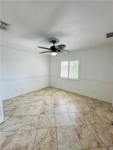 Unfurnished room with light tile patterned floors and ceiling fan