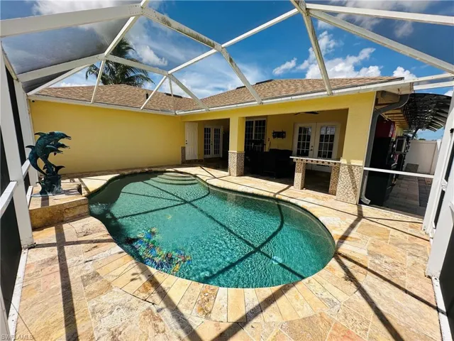 View of swimming pool with ceiling fan, a lanai, a patio, and french doors