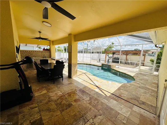 View of pool featuring ceiling fan, a patio, and a lanai