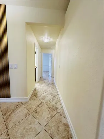 Hallway featuring light tile patterned floors